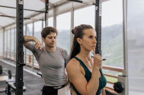 A fit couple engaged in gym exercises. Indoor workout with focus on fitness goals.